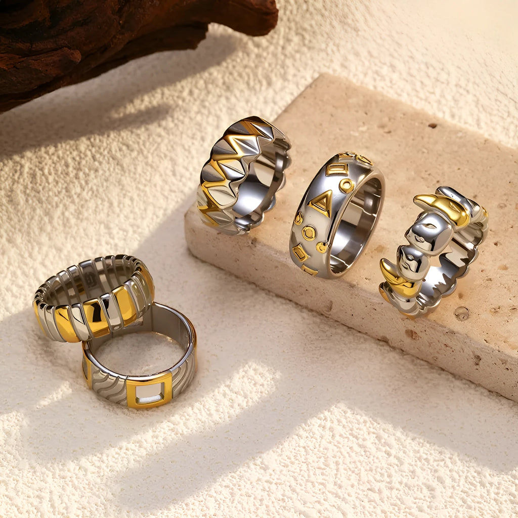 Gold and silver two-tone geometric cross stainless steel ring on a light background showing texture and electroplated finish