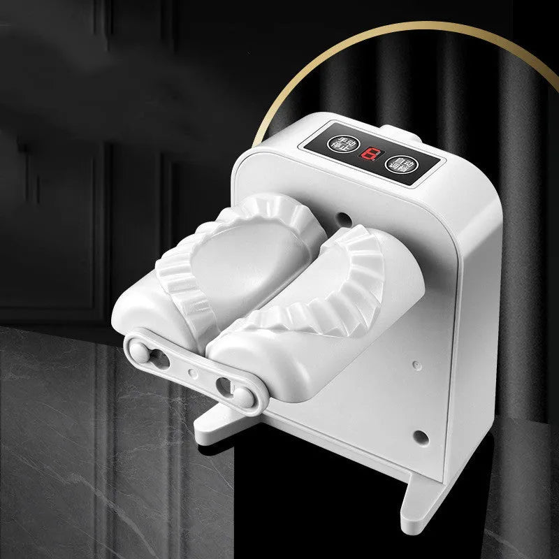 White automatic electric dumpling maker machine with USB charging cable, brush, and spoon on a kitchen counter.