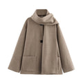 Women's long black coat with artificial fur collar, showing extended length and pocket detail.