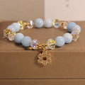 Women's aquamarine crystal bracelet with four-leaf clover design and a pearl accent.