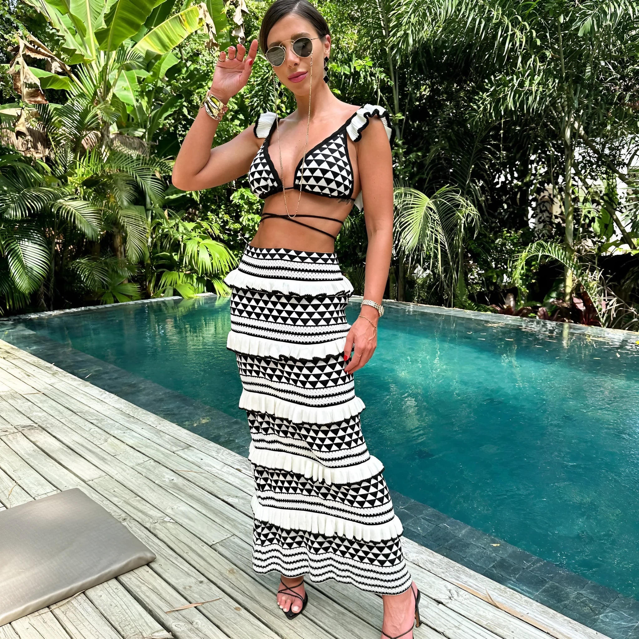 Black and white striped two-piece swimsuit set with ruffled bikini top and long knitted skirt.