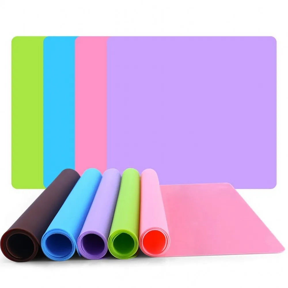 Rectangular silicone pet table mat under a dog bowl, available in multiple colours including black, blue, green, orange, purple, red, white, and yellow