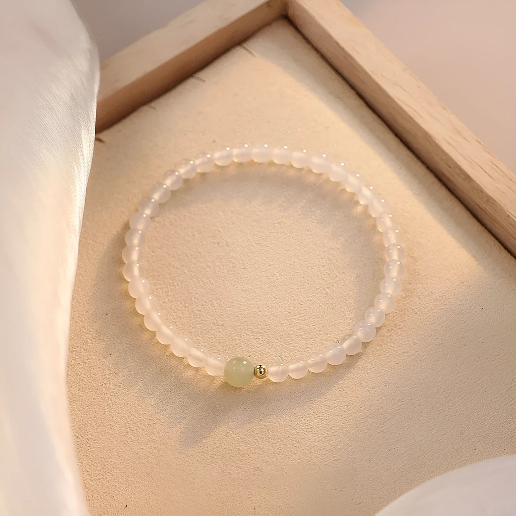 Close-up of a women's bracelet with white agate and Hetian jade beads on a 15 cm strand.