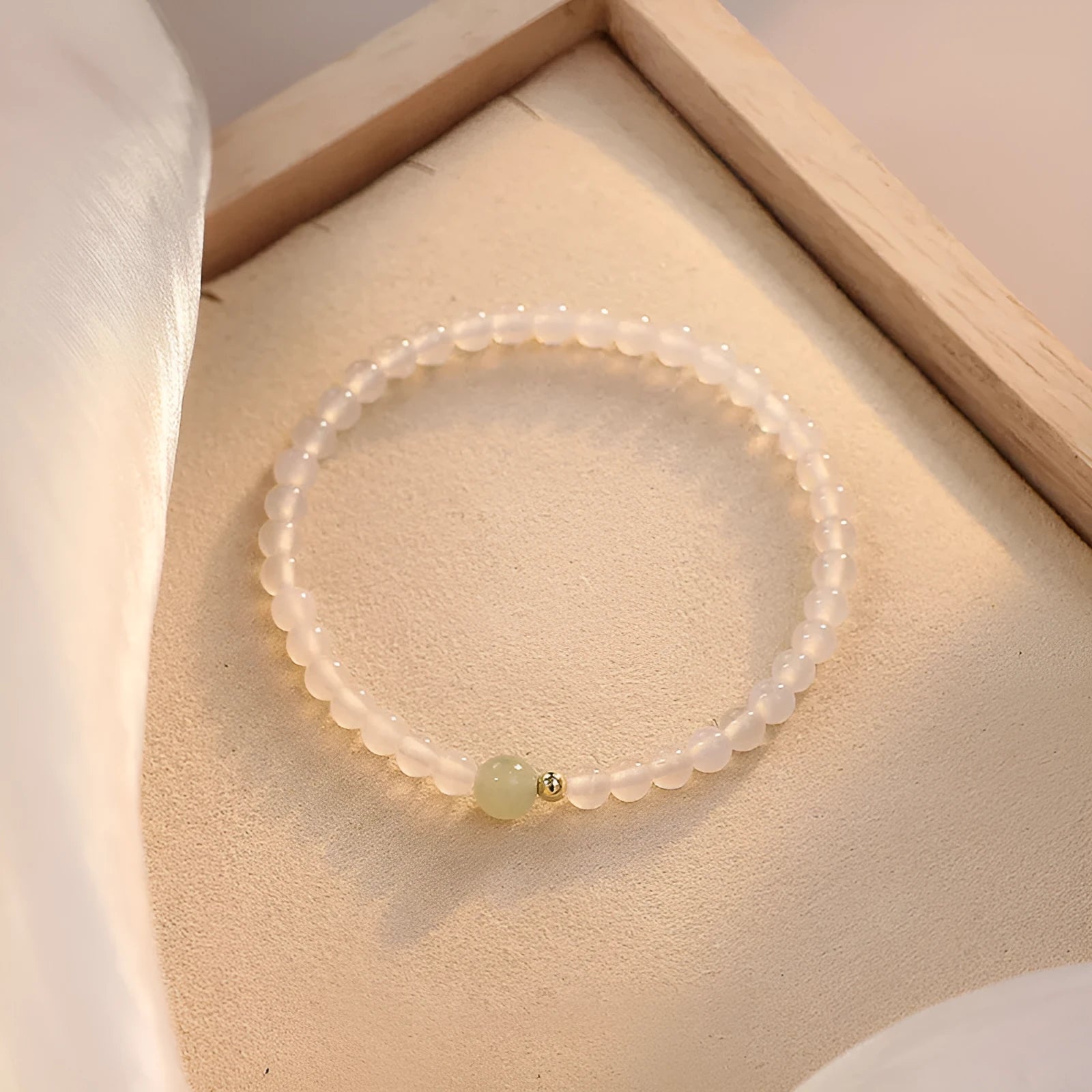 Close-up of a women's bracelet with white agate and Hetian jade beads on a 15 cm strand.