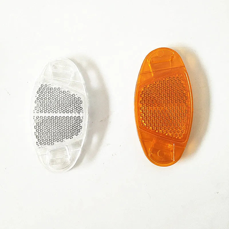 White and yellow plastic bicycle spoke reflectors showing 7.2cm length measurement