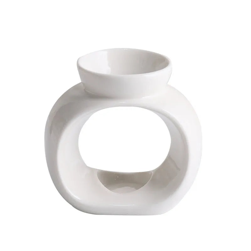 White Nordic style ceramic aromatherapy stove ornament on a wooden surface.