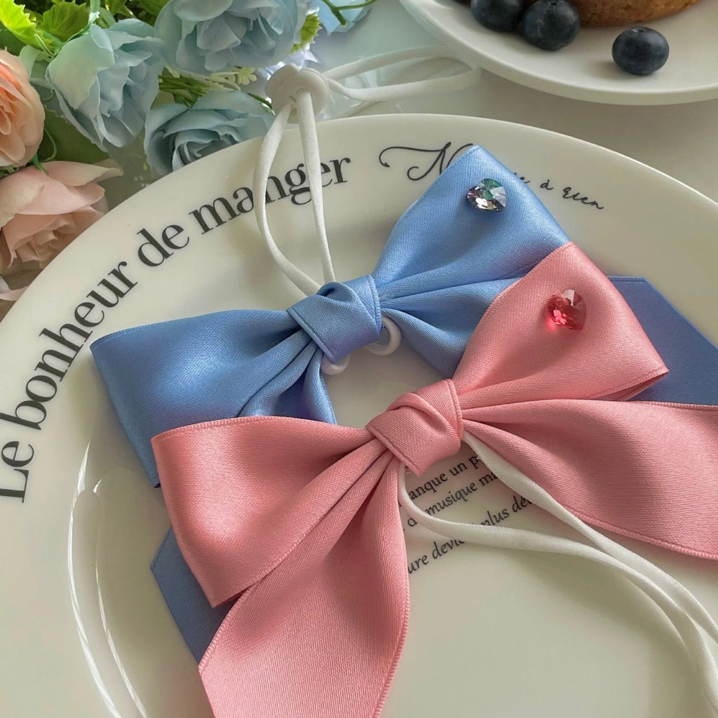 A blue dog hair band with a large princess-style bow and adjustable tension strap on a white background.