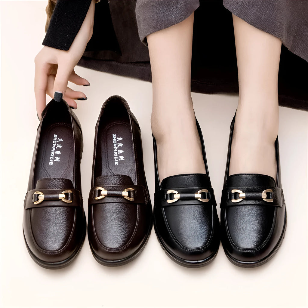 Black soft leather women's loafers with round toe and low flat heel on a rubber sole.
