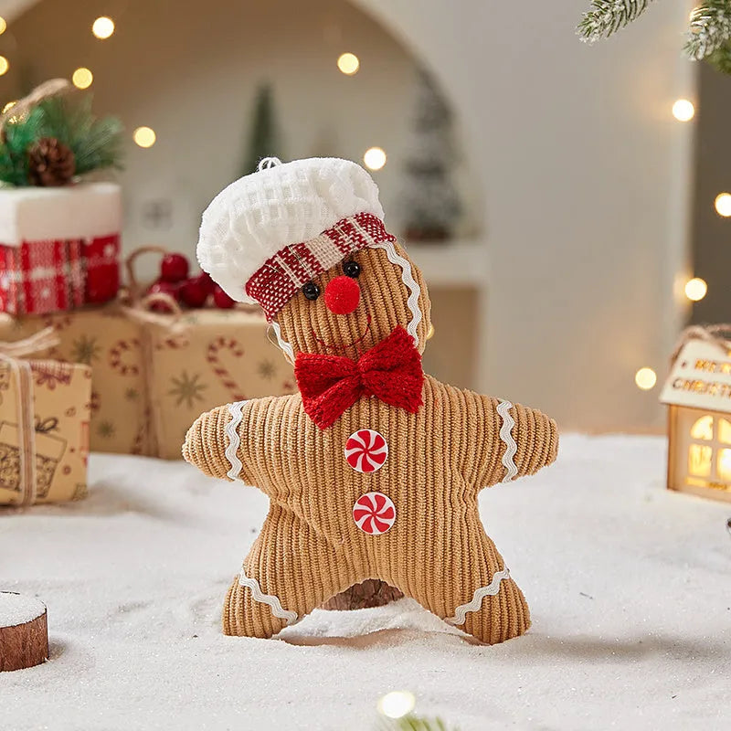 Cloth gingerbread man Christmas ornament with red hat hanging on festive branch