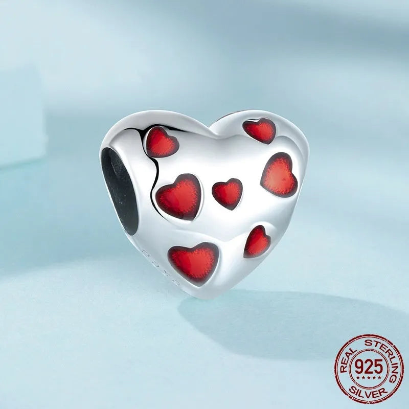 Red heart-shaped S925 sterling silver bead with glossy drip oil finish on plain background