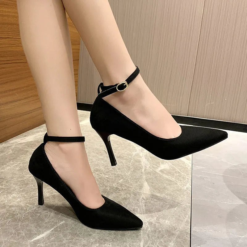 Women's black stiletto heel pump shoe with a skull pattern and buckle detail on a white background.