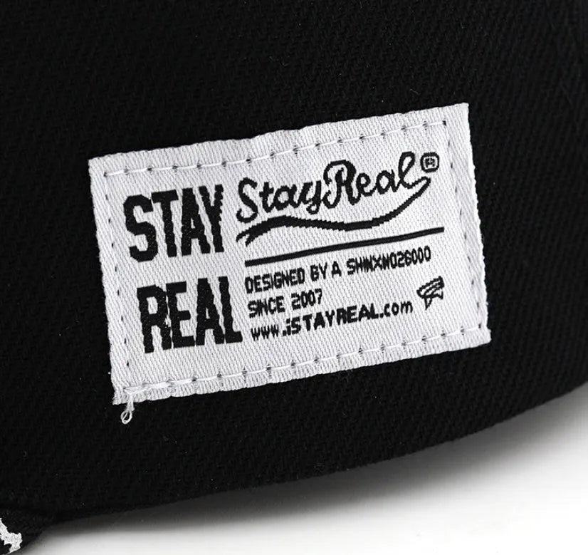 Black cotton baseball cap with white embroidered lettering on the front, showing adjustable back strap.