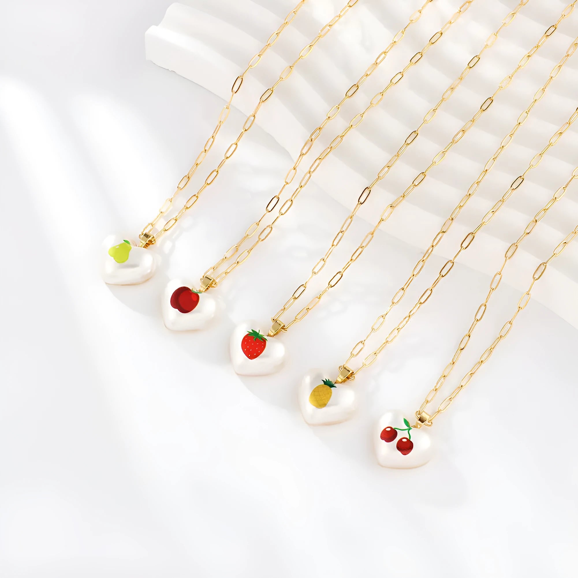 Geometric heart-shaped necklace with a detailed strawberry charm pendant on an adjustable chain.