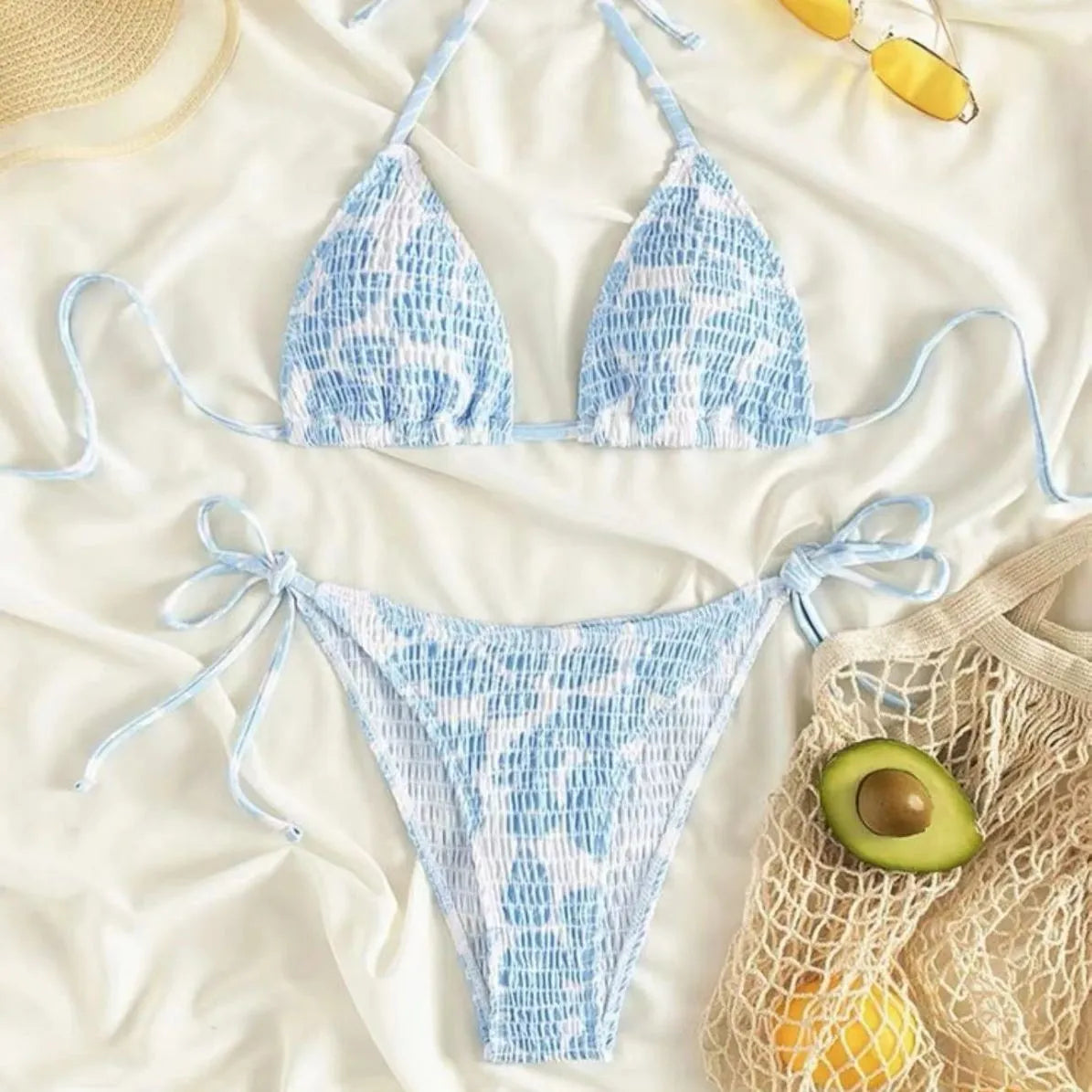 Women's floral print halter swimsuit briefs in light blue on a mannequin.