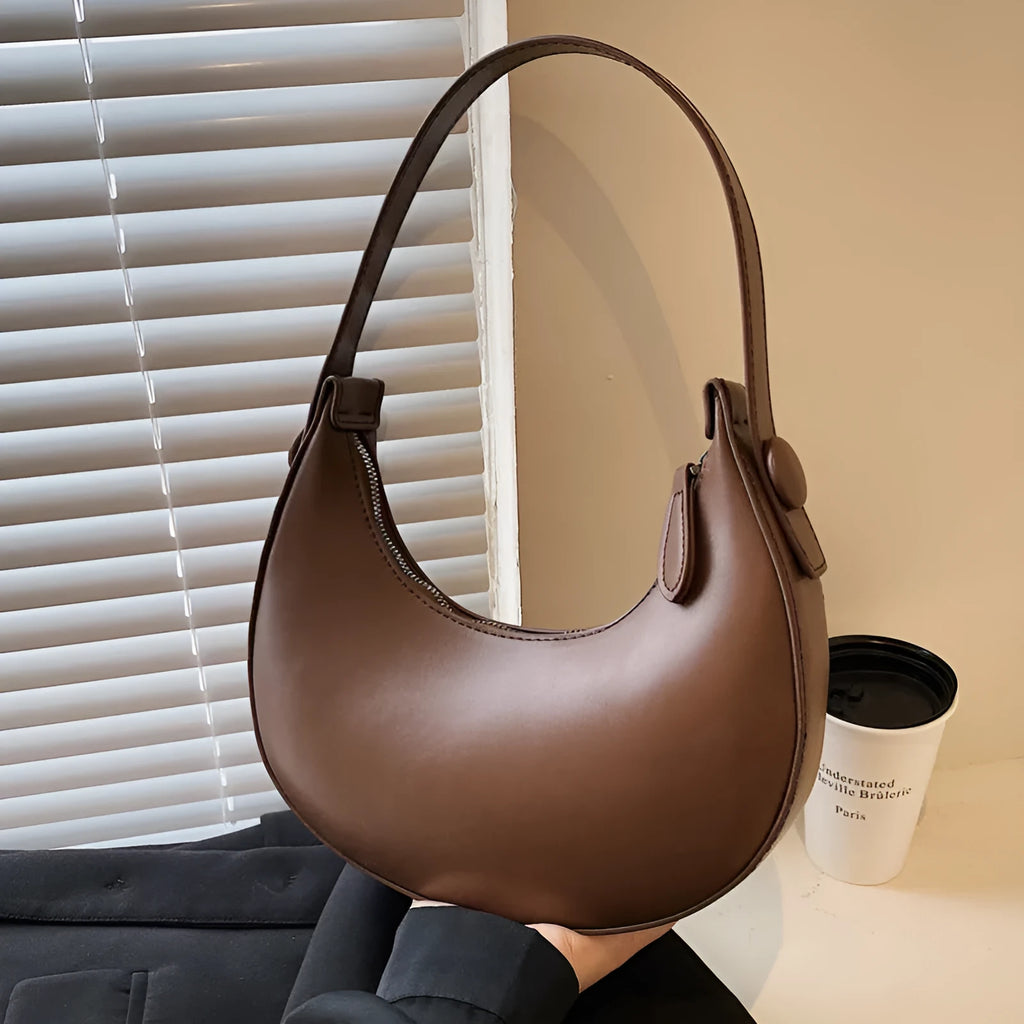 Women's retro-style PU leather shoulder bag in a dumpling shape, shown in black.