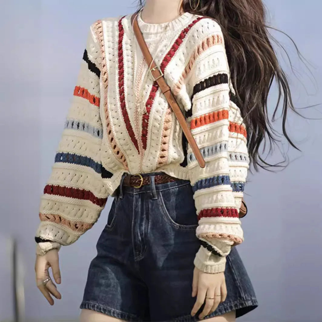 Retro rainbow striped hollow pullover sweater with batwing sleeves on a hanger.