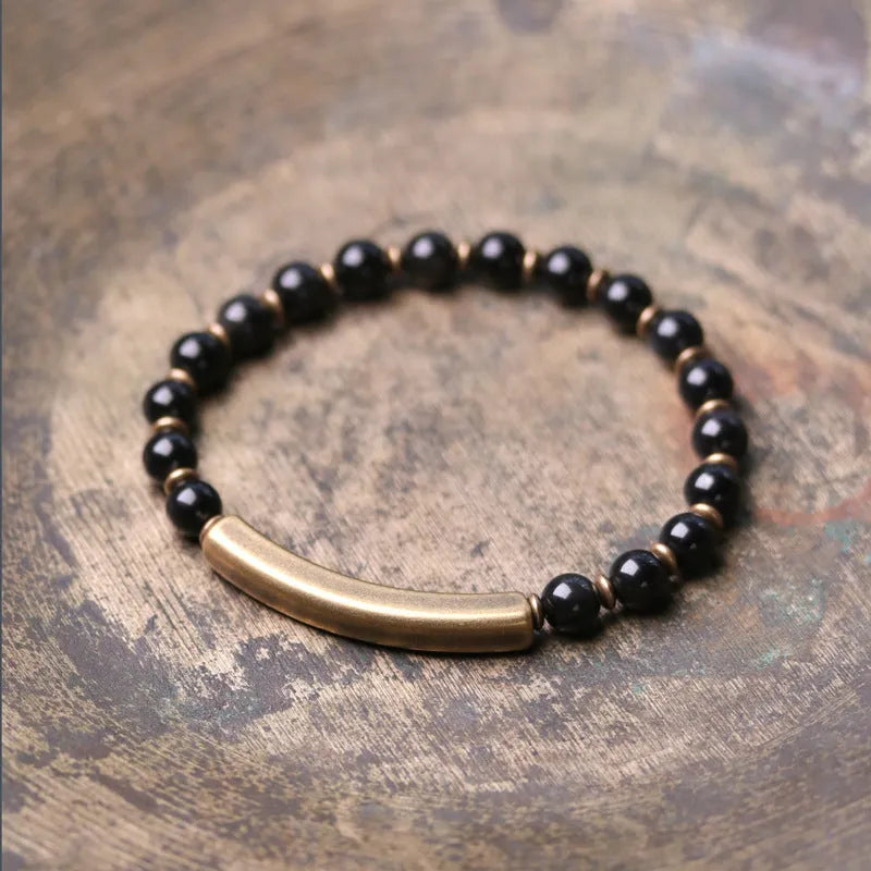 Layered retro bracelet with natural stone beads and brass details on a wrist.