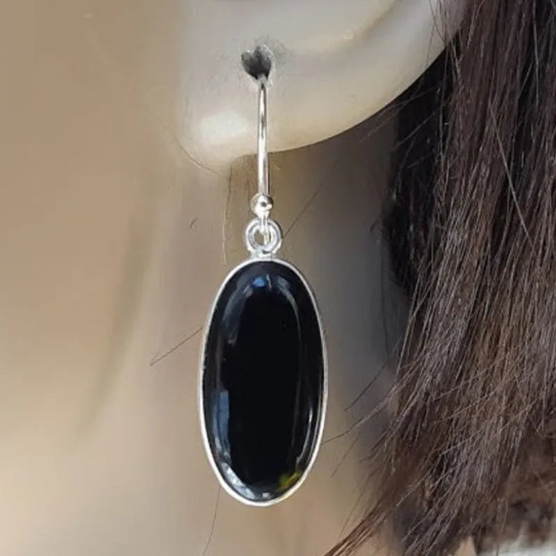 A pair of women's geometric earrings with a black agate oval pendant on alloy settings.