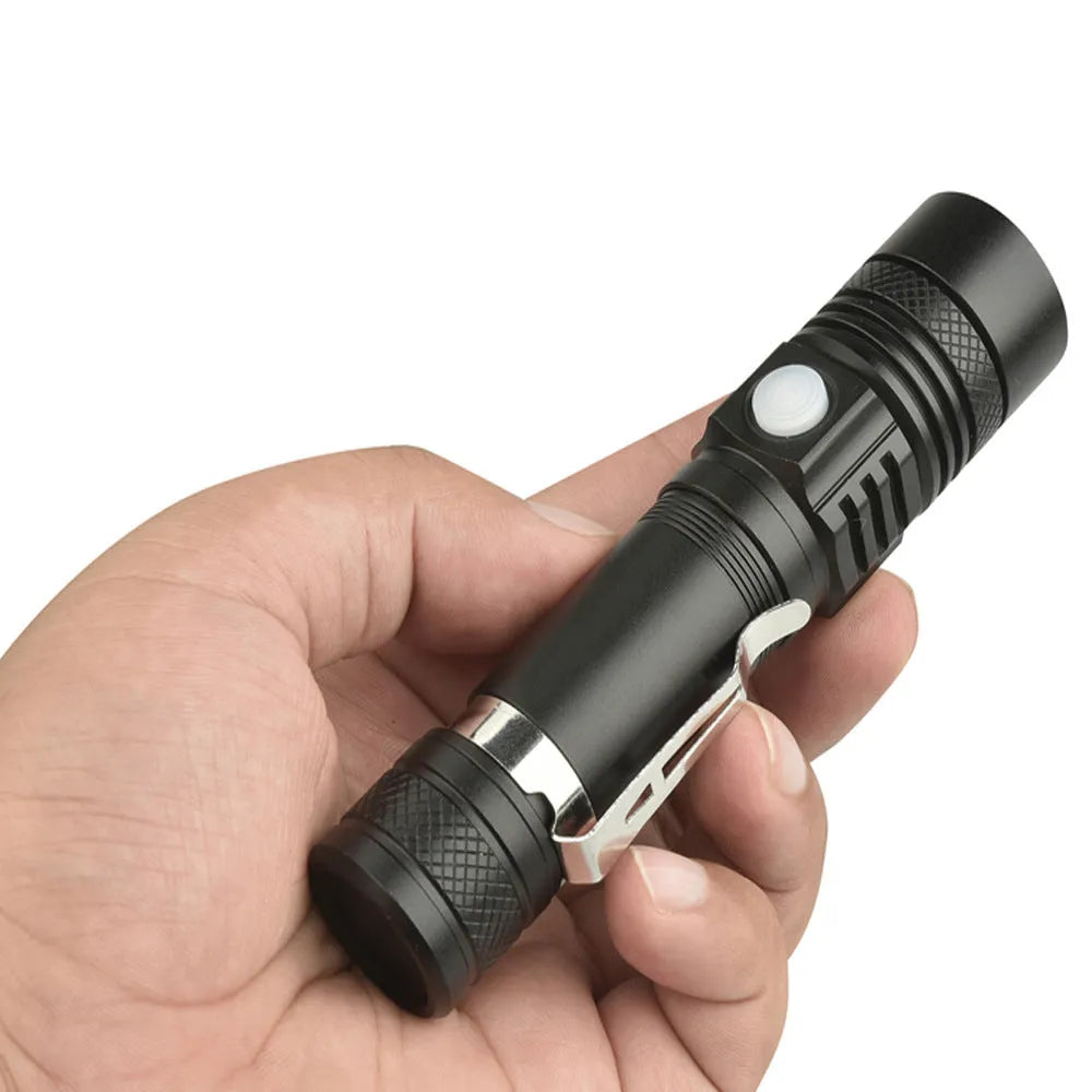 Black telescopic zoom USB rechargeable T6 LED flashlight on outdoor background