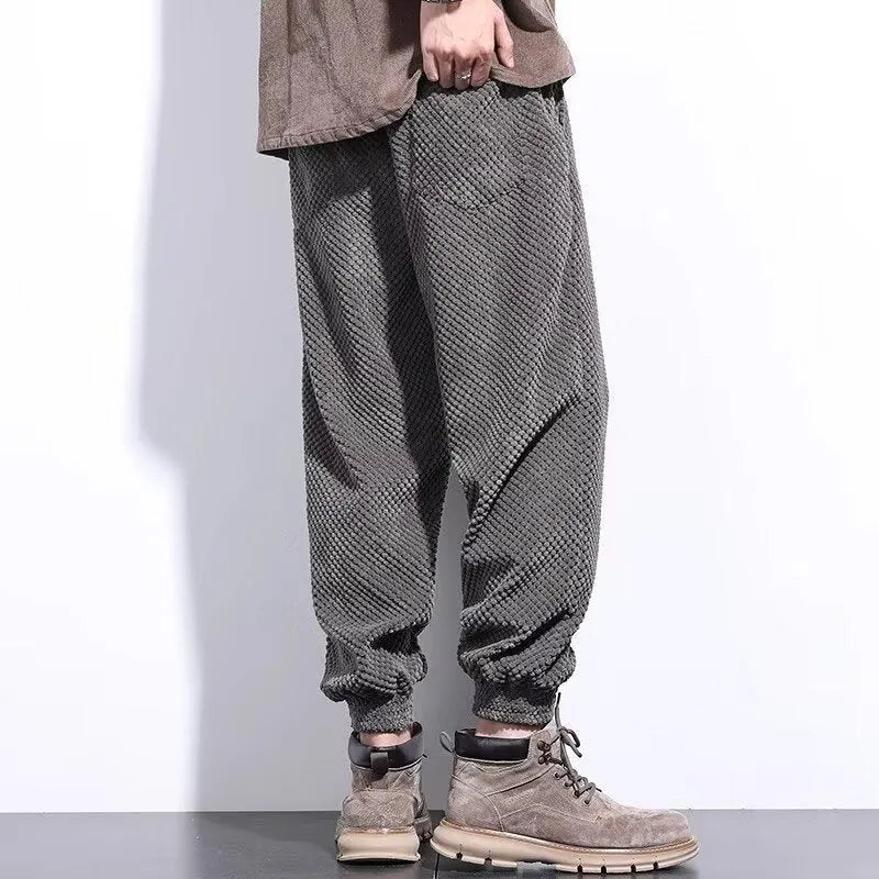 Man wearing grey straight-leg sweatpants with an ankle tie closure.