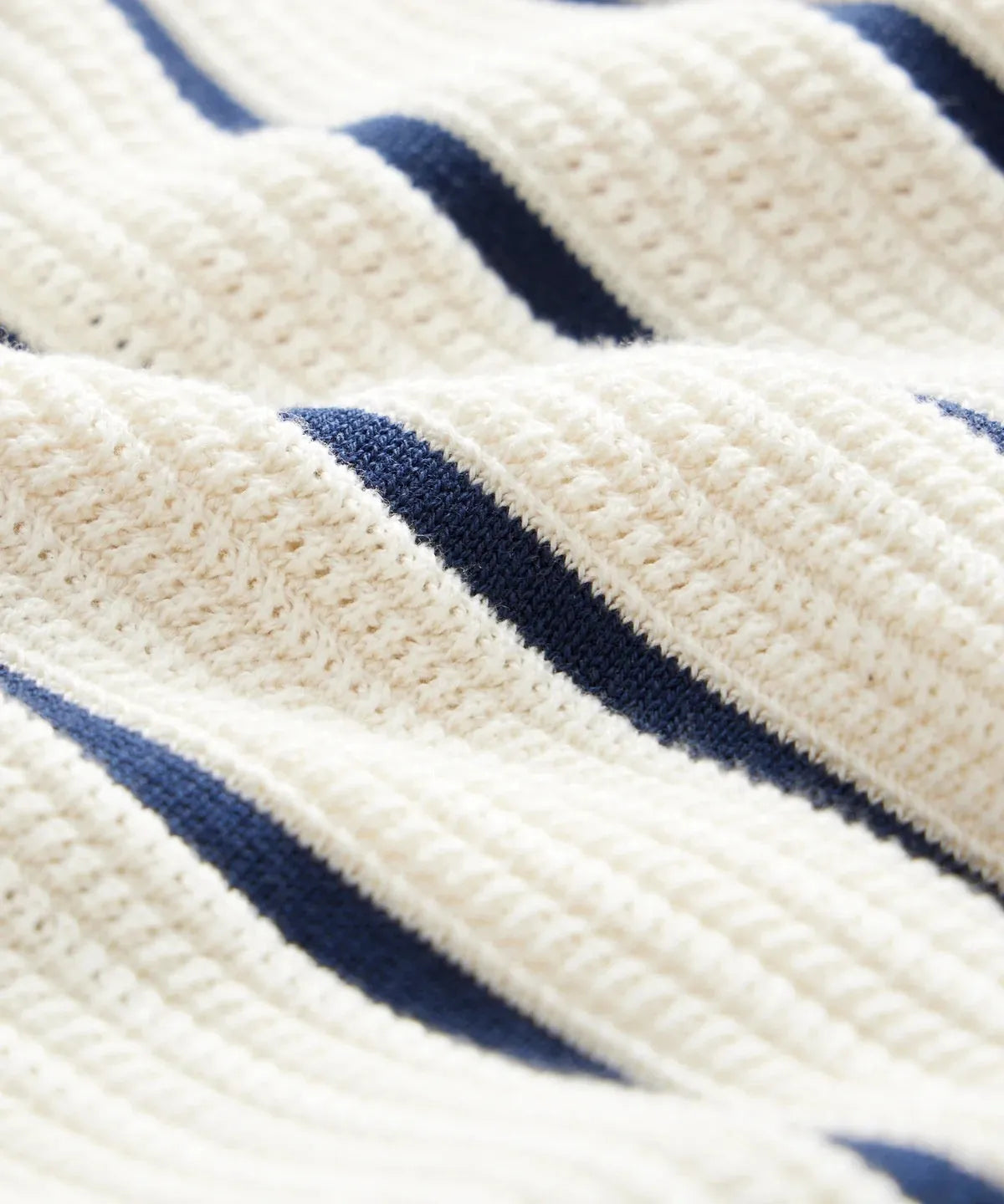 White men's lapel knitted short sleeve shirt with asymmetric stripe design on a hanger.