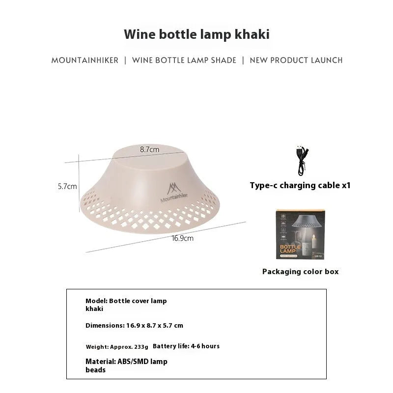 Beige wine bottle-shaped camping lantern with LED light on a wooden surface outdoors.