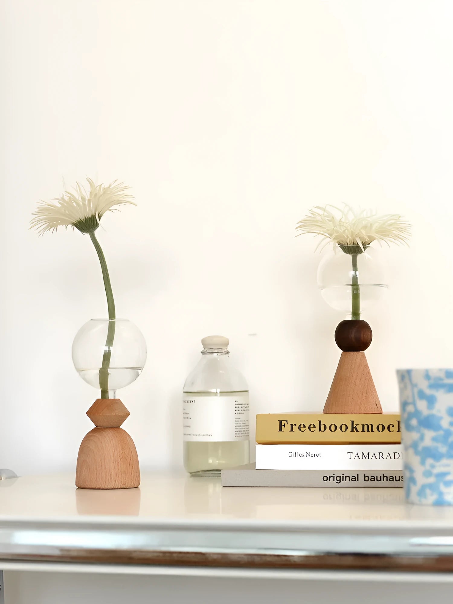 Geometric clear glass bubble vase with wooden base on tabletop with floral arrangement