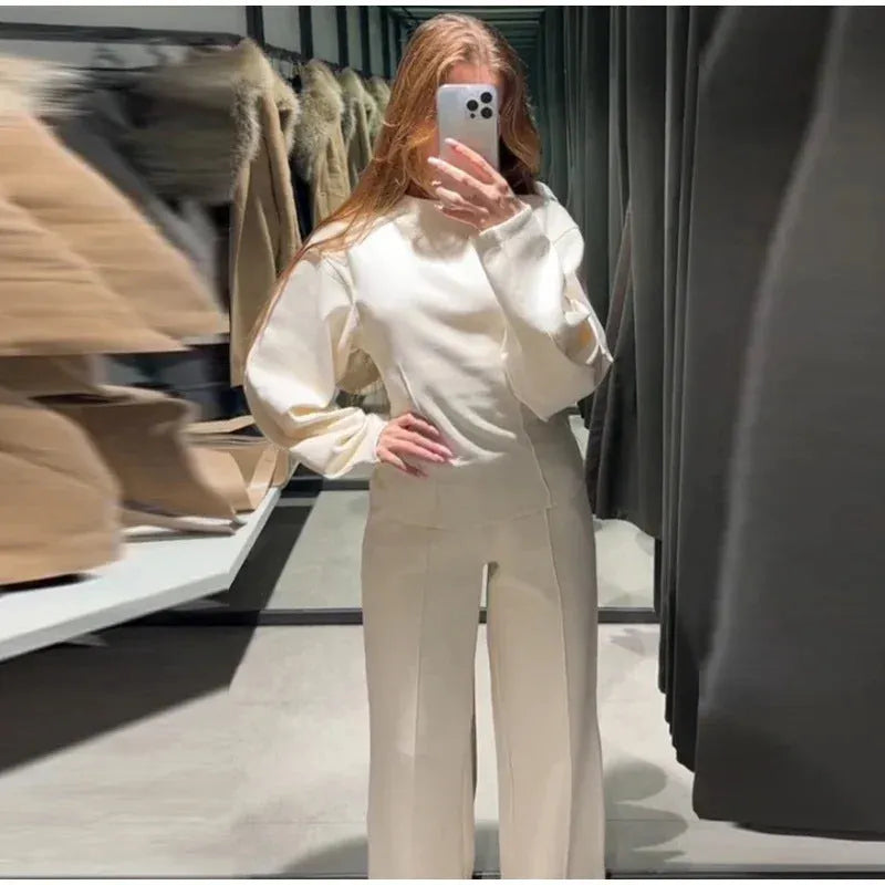 Women's black polyester fleece two-piece suit with long sleeve top and wide-leg trousers on a hanger.