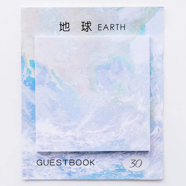 Square sticky notes notepad open to show planet oil painting designs including Earth and Rainbow Moon.