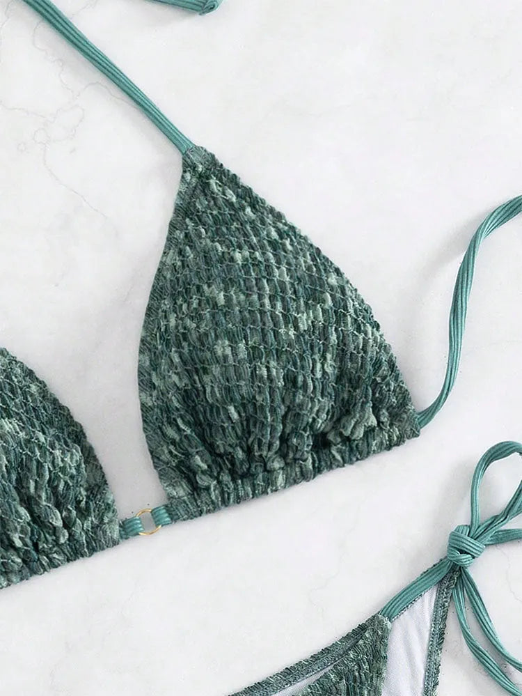 Green backless women's bikini set with halter neck strap and matching shorts.