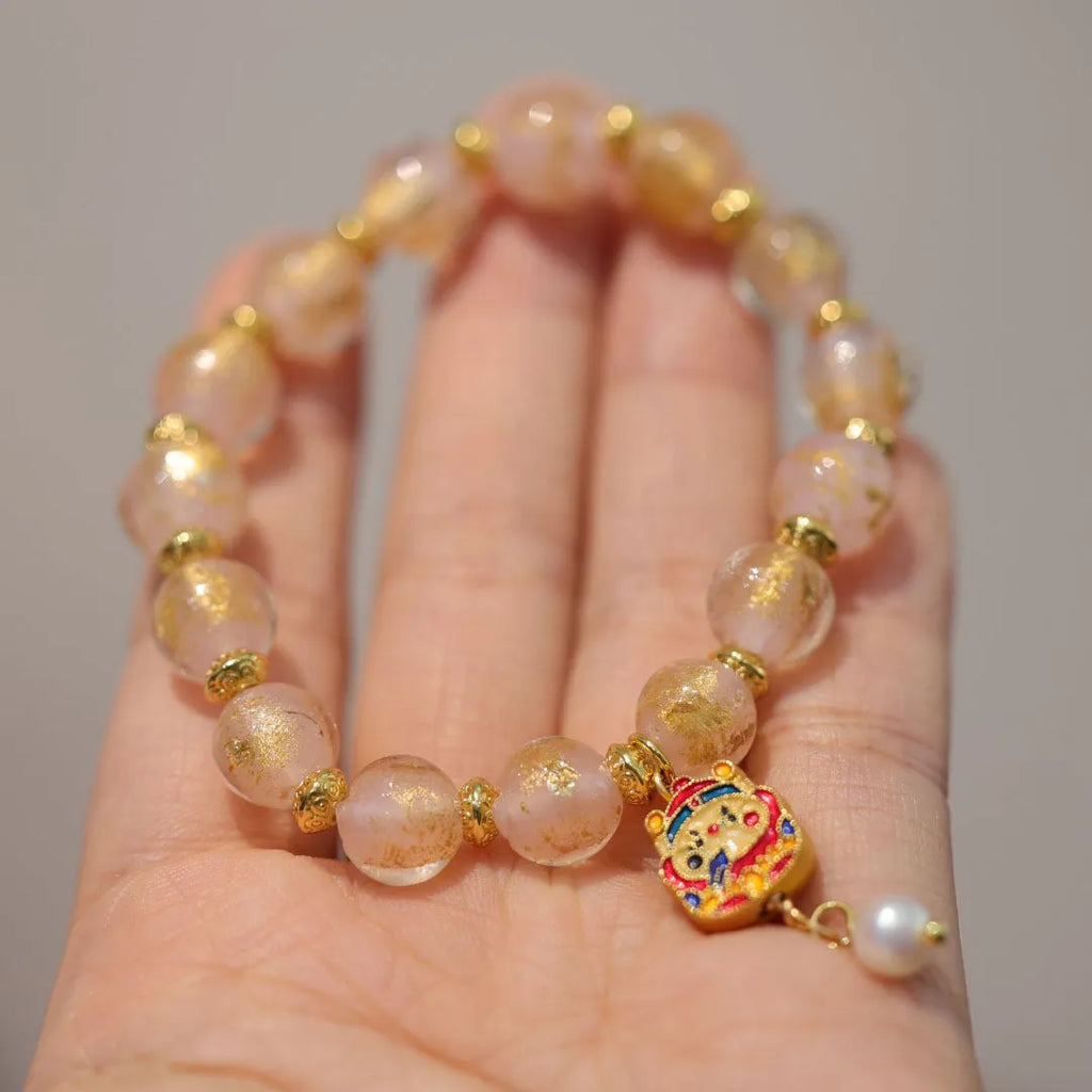 Gold foil coloured glaze ethnic bracelet with geometric Xingshi patterns and hanging gourd charms