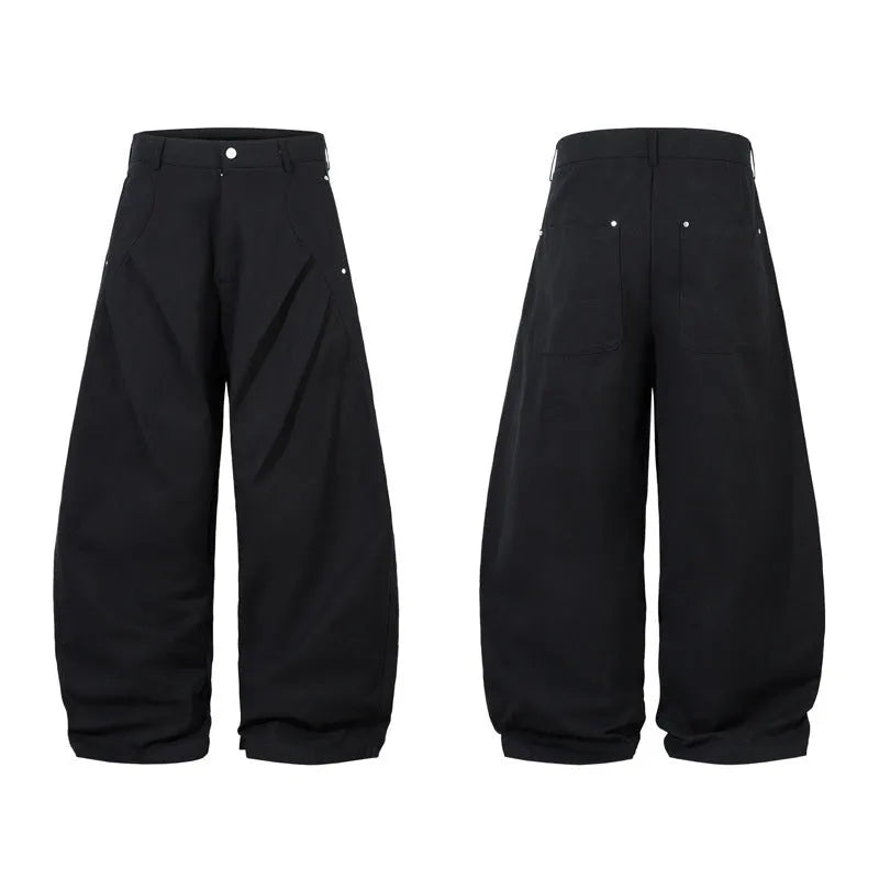Men's black pleated wide-leg cotton trousers showing loose-fitting casual design