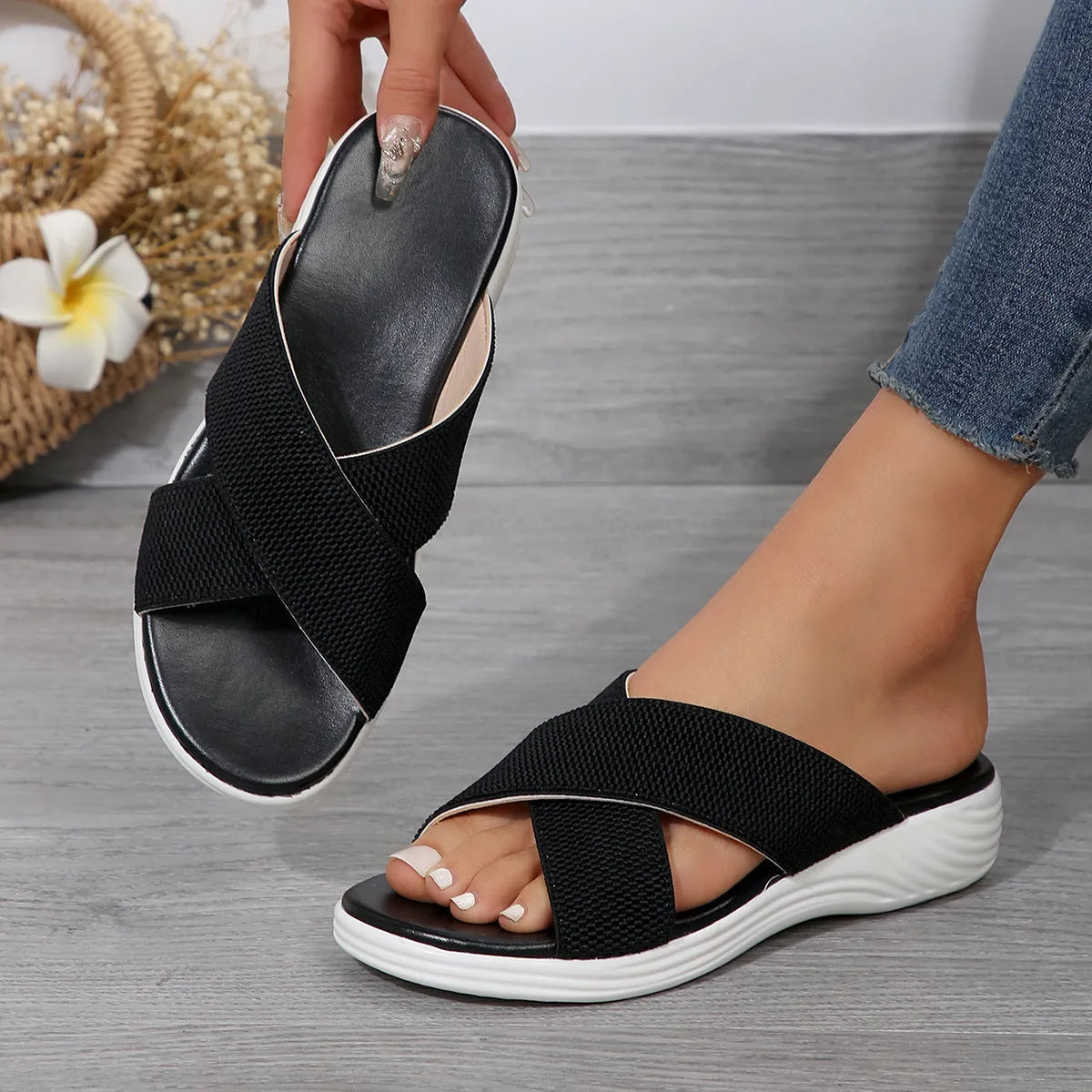 Women's black flat wedge peep-toe summer slippers with a cross-strap design on a rubber sole.