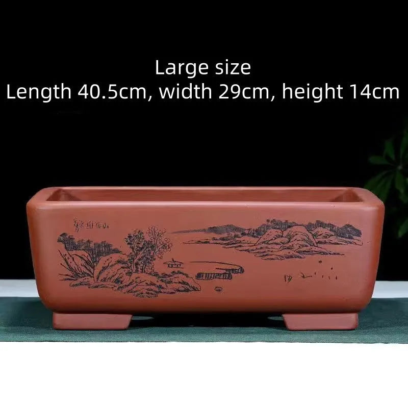 A deep blue black handmade rectangular purple clay bonsai pot on a wooden surface.