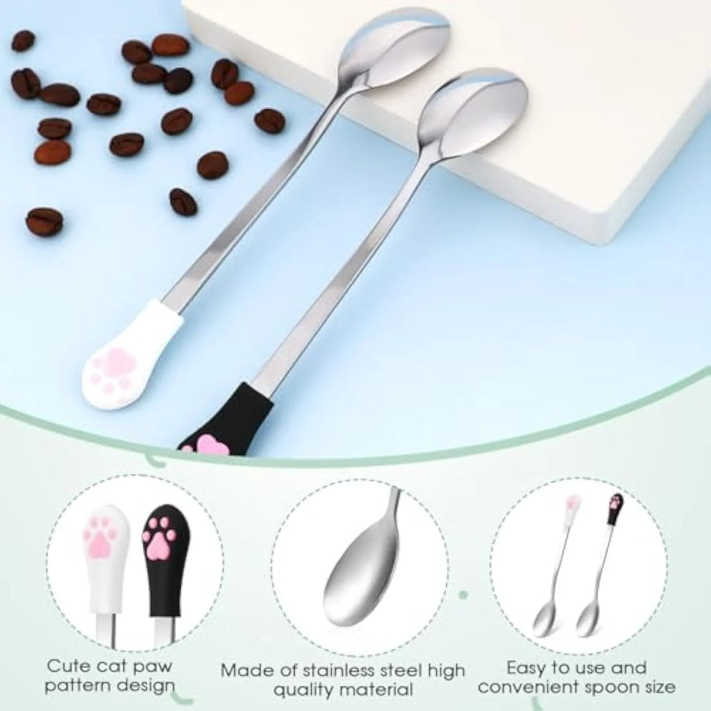 Two stainless steel pet food spoons with silicone grips, one white and one black, featuring a cat paw print.