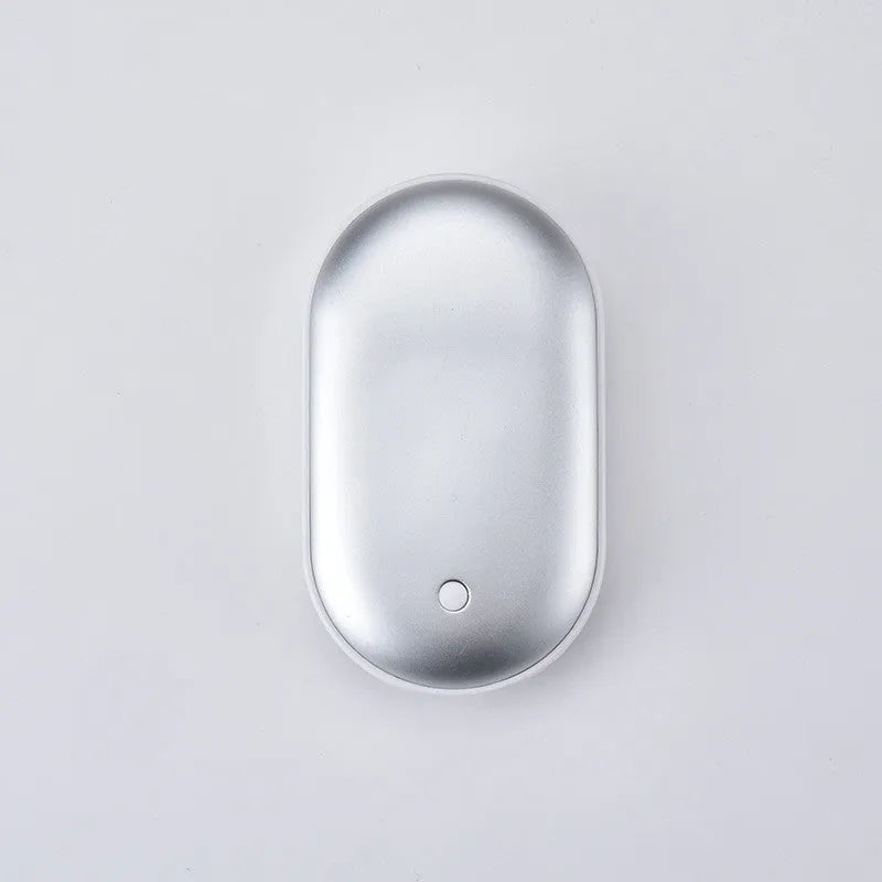 Compact rechargeable hand warmer and power bank in rose gold finish showing size relative to a hand.
