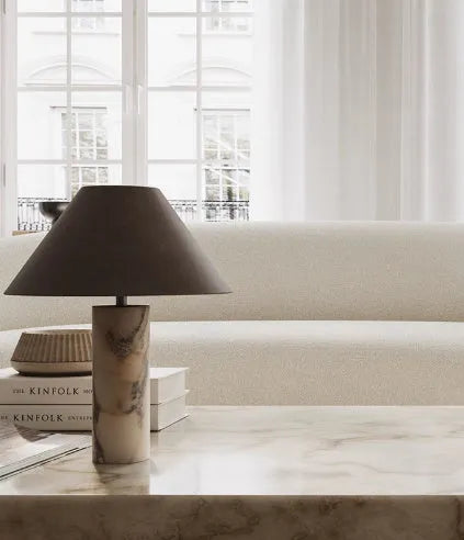 Modern black table lamp with a textured marble base on a wooden desk.