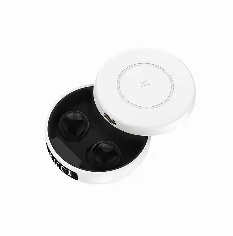 Small black semi-in-ear wireless headphones with their wireless charging case on a table.