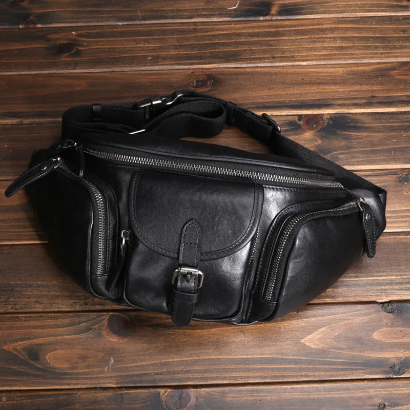 Black slanted chest bag in first layer cowhide with lock detail and polyester lining for daily commute