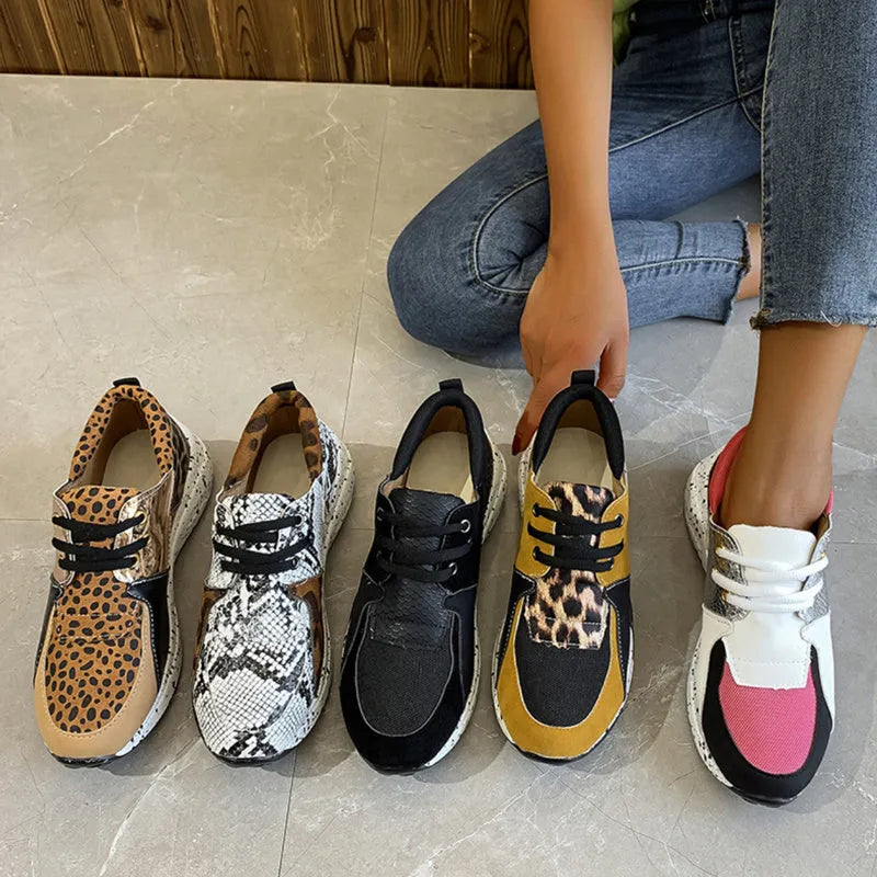 Women's casual wedge heel sneakers in suede, showing round toe and low-cut profile on a wooden floor.