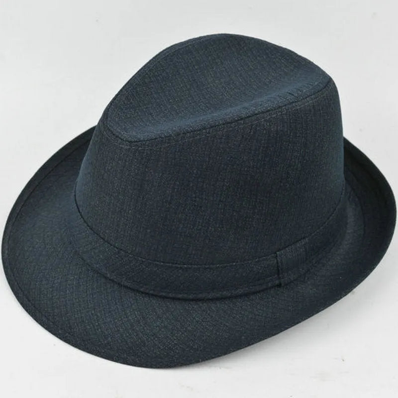 A man's brown fedora hat with a pinched crown and a medium-width brim on a wooden table.