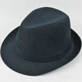 A man's brown fedora hat with a pinched crown and a medium-width brim on a wooden table.
