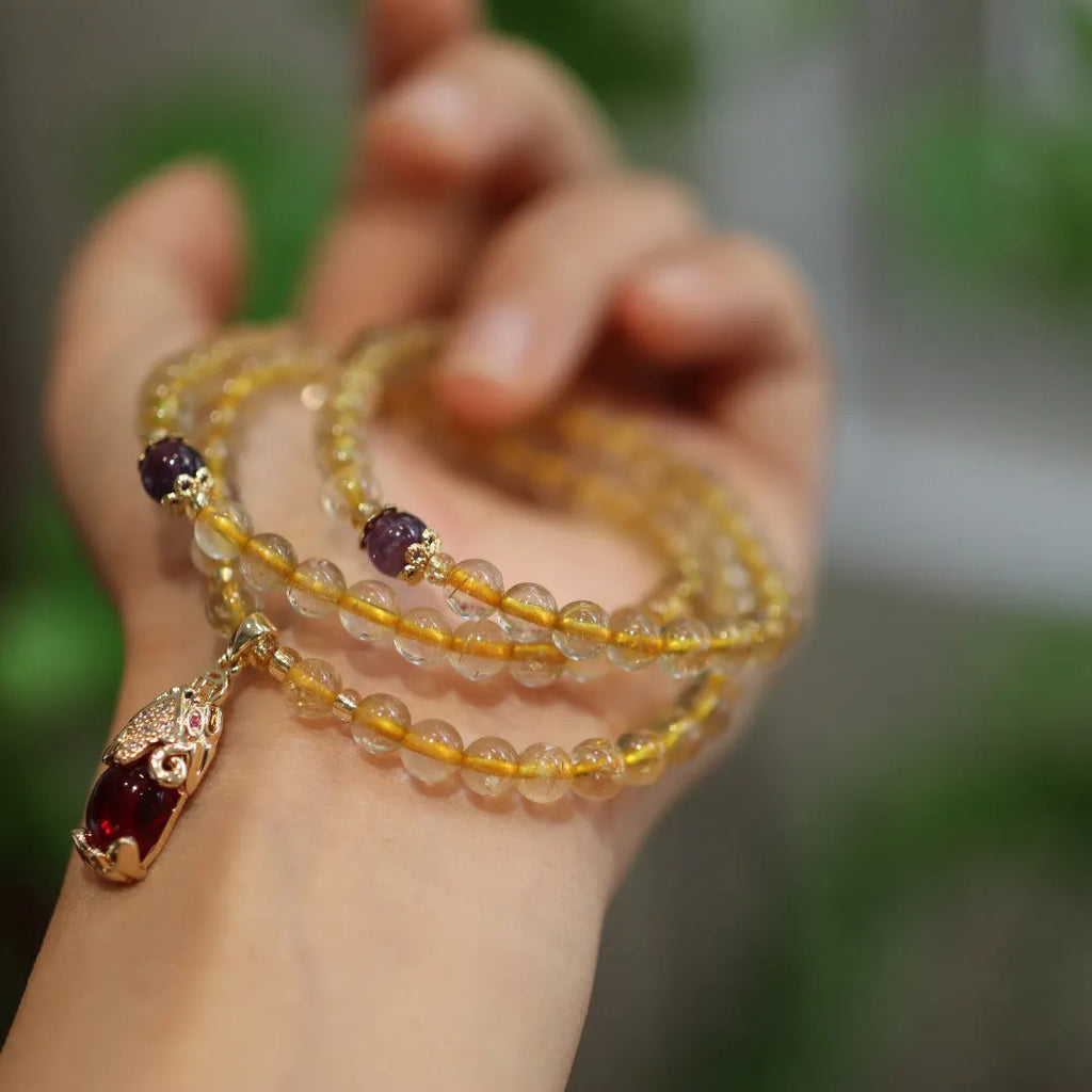 Natural Brazilian rutilated quartz bracelet in Chinese style with three circles and hanging chopsticks.