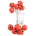 LED Halloween string lights with warm white glow and iron pumpkin pendants on a dark background