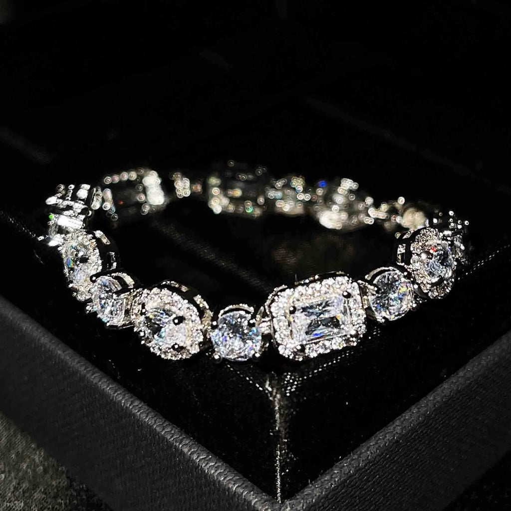 Women's geometric silver bracelet with inlaid white zircon stones on a wrist, showing adjustable clasp.
