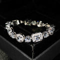 Women's geometric silver bracelet with inlaid white zircon stones on a wrist, showing adjustable clasp.