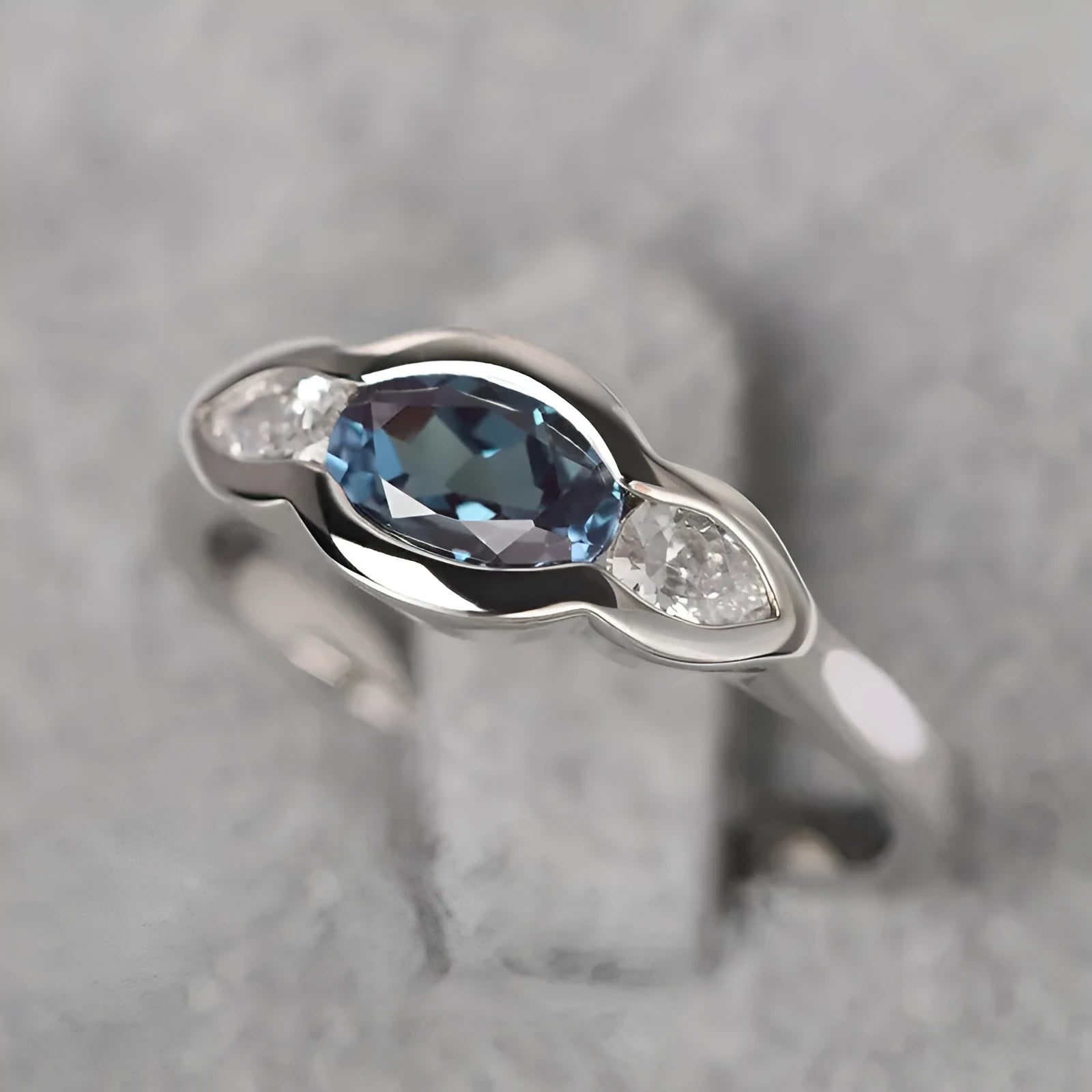Geometric ellipse ring with zircon inlay in white gold colour, showing contemporary jewellery design