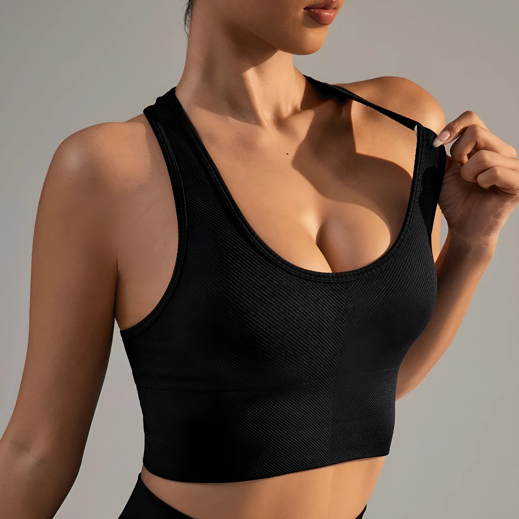 Black women's cross-back sports bra with fixed double straps and moulded cups.