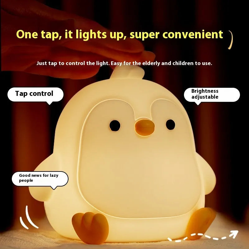 Baby penguin silicone small night lamp in black with warm light mode on bedside table