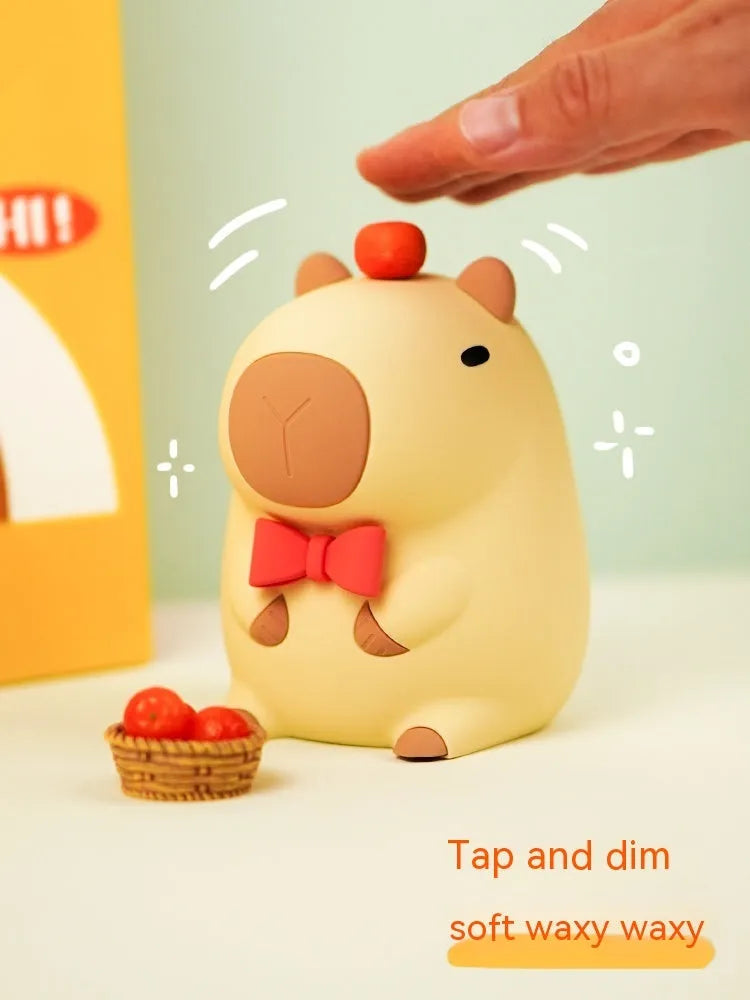 Cute brown Capybara silicone night lamp with soft glow on a bedside table.